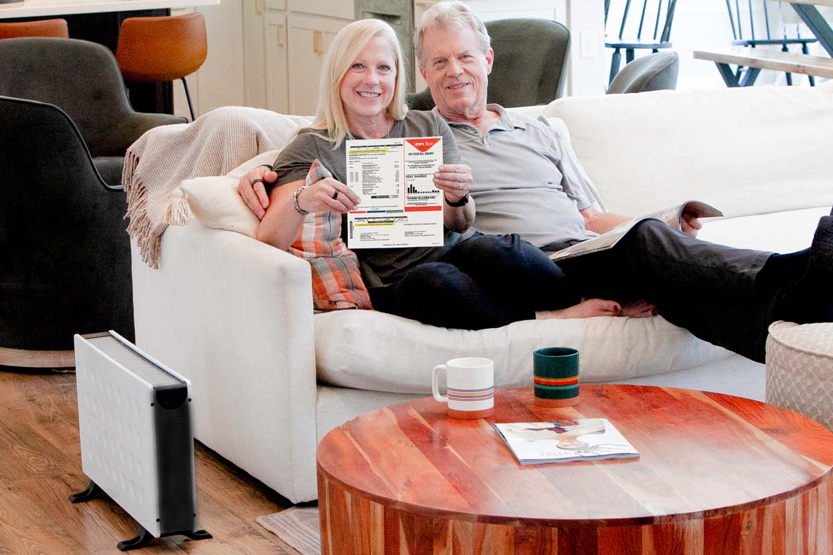 A couple on their couch showing off their bill savings with a Power Panel Original next to them