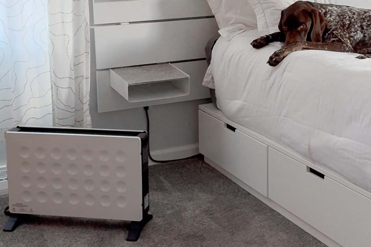 A dog laying on a bed in the bedroom with a Power Panel Original on the floor near by